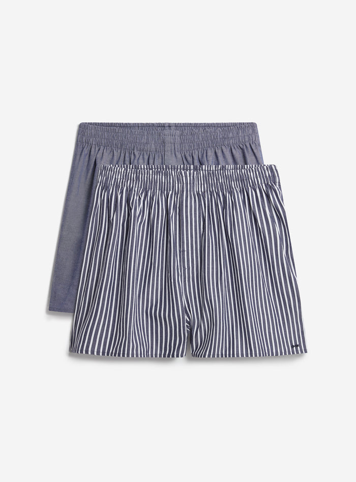A two-pack of Percival cotton boxers, with one plain blue pair and one navy and white striped pair, on a white background.
