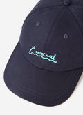 A close-up of the Percival Amor Embroidered Cap in navy, showing the detailed light blue logo stitching on the front.
