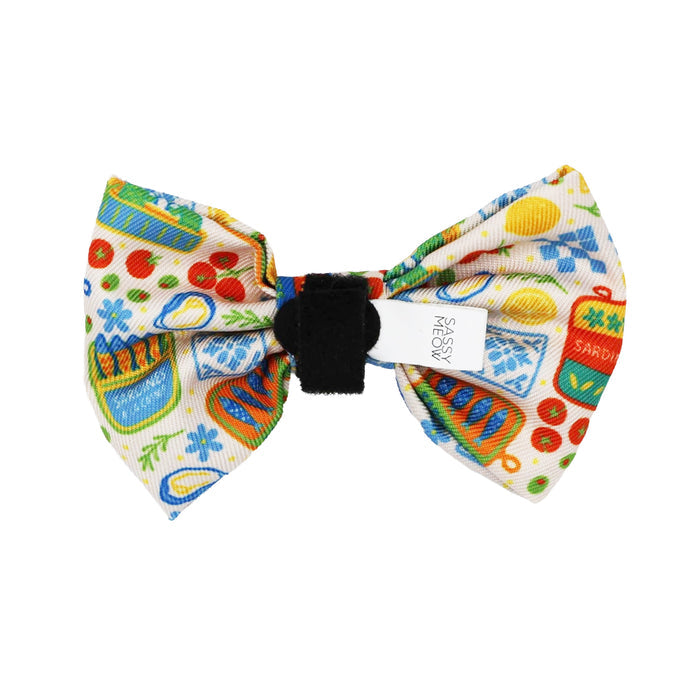 The Sassy Woof Cat Bowtie - Portofino showcases a vibrant kitchen-themed print on white with a black center band, ideal for adding playful flair to any lightweight cat collar or harness.