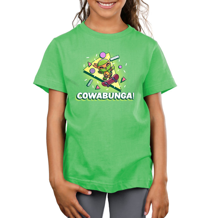 Premium Cotton T-shirt_TeeTurtle apple green Cowabunga! apparel featuring Michelangelo from Teenage Mutant Ninja Turtles on a skateboard with retro 90’s graphics in the background.