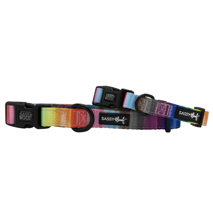 Two Sassy Woof "Love You Fur You" dog collars with black buckles and metal rings are stacked against a white background, featuring a rainbow gradient pattern and Sassy Woof branding on black tags.