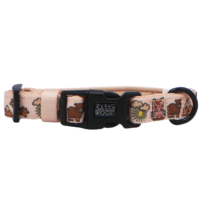 The Sassy Woof Dog Collar - National Bark is a light pink neoprene collar with a plastic buckle, featuring printed cows, sunflowers, and farm icons. Adjustable and stylish, it’s perfect for any outdoor dog accessories collection.