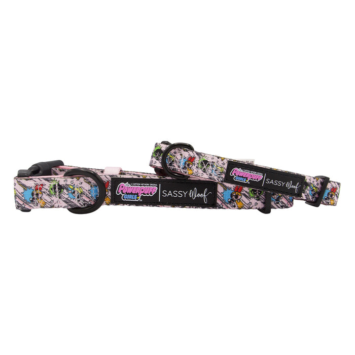 Two Sassy Woof “The Powerpuff Girls™” Dog Collars (Pink) feature adjustable sizing, black plastic buckles, a branded label, and vibrant multicolored cartoon graphics on a light neoprene background.