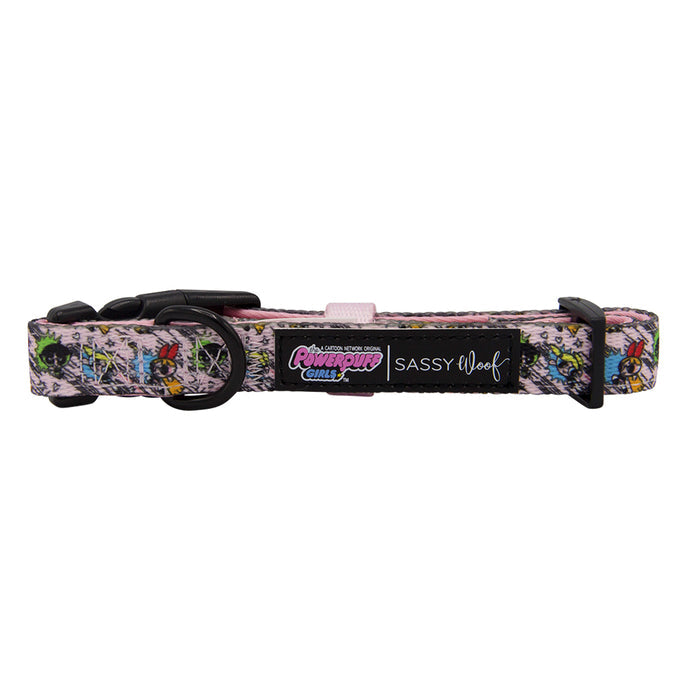 The Sassy Woof Dog Collar - The Powerpuff Girls™ (Pink) features vibrant graphics, a black plastic buckle, metal ring, and tags with Powerpuff Girls and Sassy Woof logos on a pink and multicolored adjustable neoprene band.