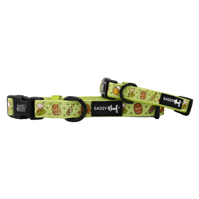 Two green neoprene Sassy Woof "Wurst Behavior" dog collars with black buckles and playful picnic-themed patterns are shown side by side on a white background.