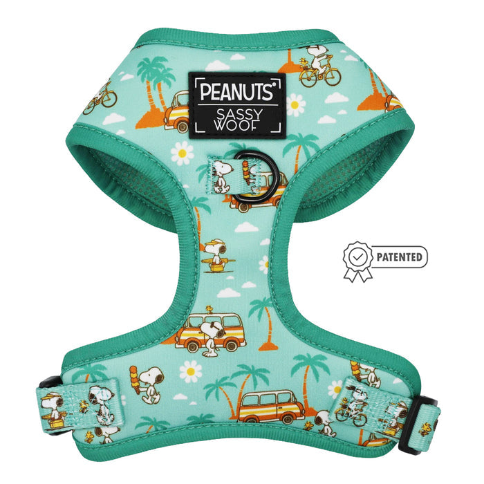 The Sassy Woof Dog Four Piece Bundle - Peanuts™ Road Tripping features a turquoise adjustable harness with Snoopy and Woodstock among palm trees, daisies, and clouds. Includes “Sassy Woof” and “Peanuts” labels and a patented icon on the side.