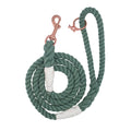 The Sassy Woof Dog Rope Leash - Amazon is a hand-crafted green cotton rope dog leash with white wrapped accents and a rose gold metal clip, shown coiled neatly on a white background.