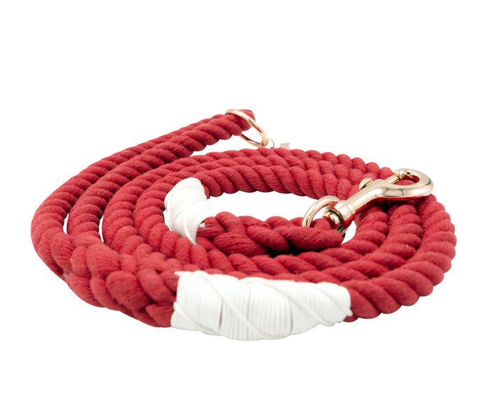The Sassy Woof Dog Rope Leash - Crimson is a coiled red cotton leash with white thread accents and a metallic clasp, offering a stylish and durable choice for daily dog walks.