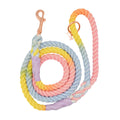 The Sassy Woof Dog Rope Leash - Fiesta is a hand-crafted cotton leash with twisted pastel strands in yellow, green, blue, pink, and orange, featuring a sturdy metal clasp and coiled neatly for style and convenience.