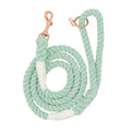 The Sassy Woof Dog Rope Leash - Mint to Be is a mint green cotton leash with white accents, featuring a rose gold metal clasp and matching ring. Durable and stylish, it’s coiled neatly for display against a white background.