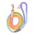 The Sassy Woof Dog Rope Leash - Piñata features a hand-crafted cotton rope with a coiled pastel ombre design—blue, purple, pink, yellow, orange, and green—and rose gold metal clip and ring attachments.