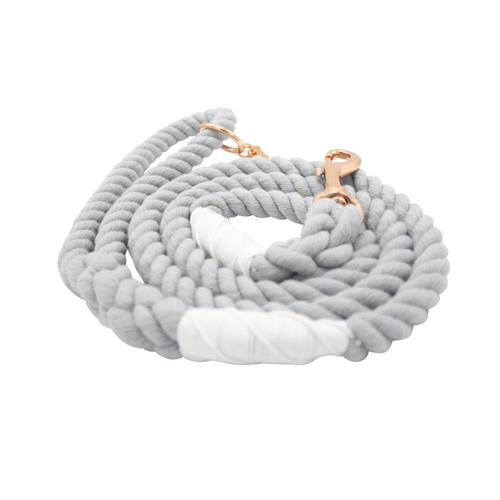 The Sassy Woof Dog Rope Leash - Serenity features a coiled, light gray cotton design with white accent wraps and rose gold hardware, including sturdy metal clips, shown on a white background.