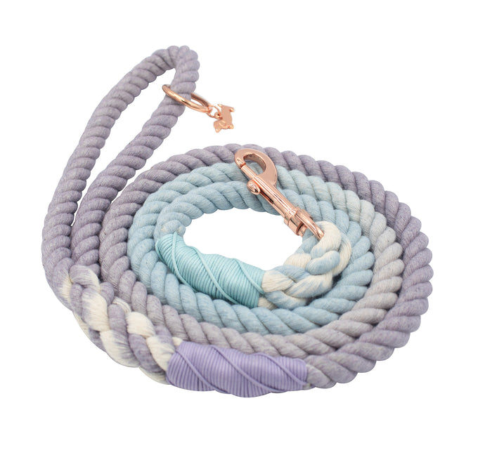 The Sassy Woof Dog Rope Leash - Skyfall features hand-crafted ombre shades of purple, blue, and cream, wrapped thread accents, and a rose gold metal clasp.