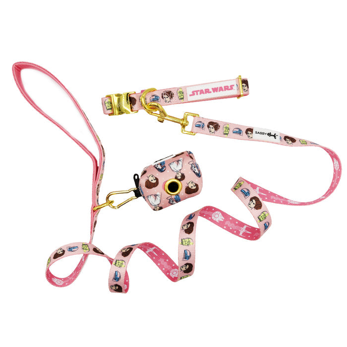 The Sassy Woof Dog Three Piece Bundle - STAR WARS™ Princess Leia features a pink collar, leash, and waste bag holder with cartoon character faces and gold hardware, displayed on a white background.