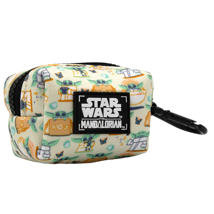 The Sassy Woof Dog Waste Bag Holder - STAR WARS™ The Child™ is a small, rectangular neoprene cream holder with Mandalorian-themed cartoon icons and a black clip—perfect as a handy dog leash accessory.