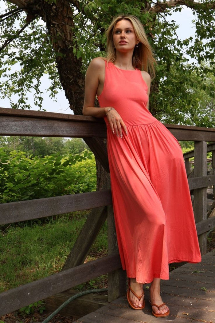 Woman wearing a coral high crew neck midi dress with a gathered waist and side pockets, styled outdoors from The Pink Doxie Boutique.