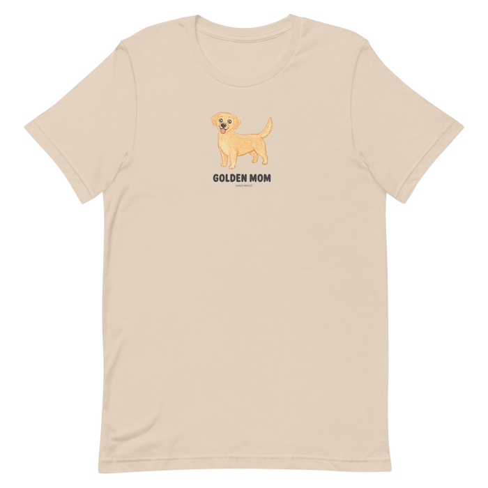 The Golden Mom Tee by Sassy Woof is a beige shirt with a golden retriever illustration and "GOLDEN MOM" text on the front. This unisex tee is perfect for proud pet parents and makes a great gift for golden retriever lovers.