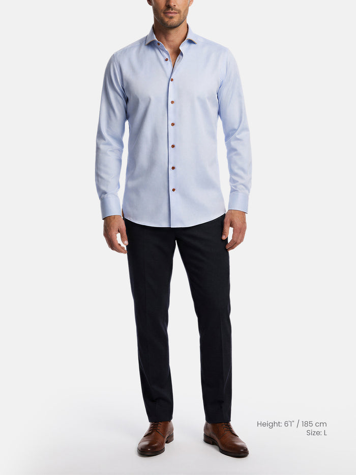 Model wearing light blue men’s dress shirt styled with black trousers and leather shoes