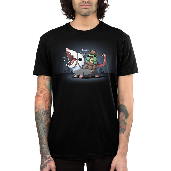 Premium Cotton T-shirt_TeeTurtle black Howdy apparel featuring an frog wearing a cowboy outfit riding an opossum like a horse.