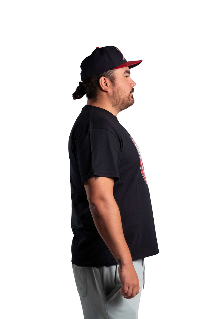 Man wearing a black INAC Distressed Feather tee with red logo side view