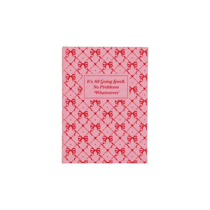 Pink notepad with red bow pattern and quote: "It's All Going Swell, No Problems"