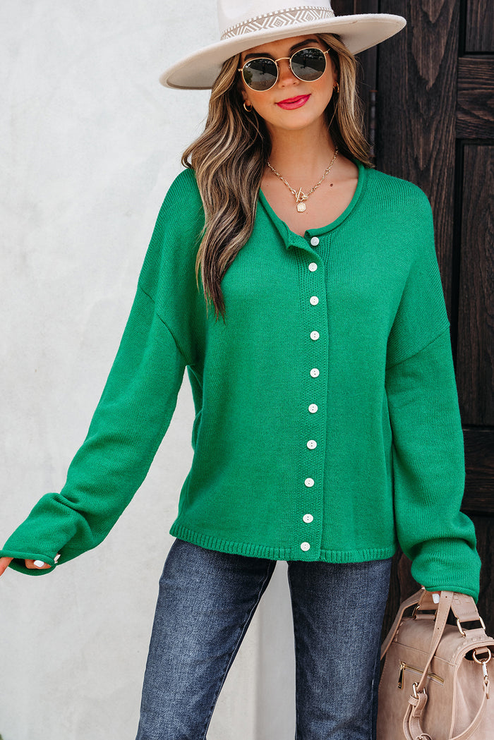Green knit button-front drop shoulder sweater cardigan styled with jeans.