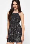 Woman wearing a black printed playsuit on a white background
