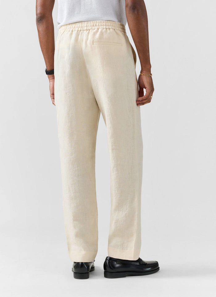 The back of a model wearing Percival's Lorena Wide Leg Trousers in cream linen, showing the elasticated waistband detail.