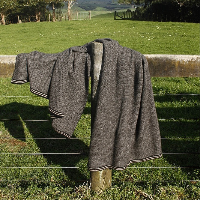 Lightweight blanket folded on fence. Colour Black/Natural