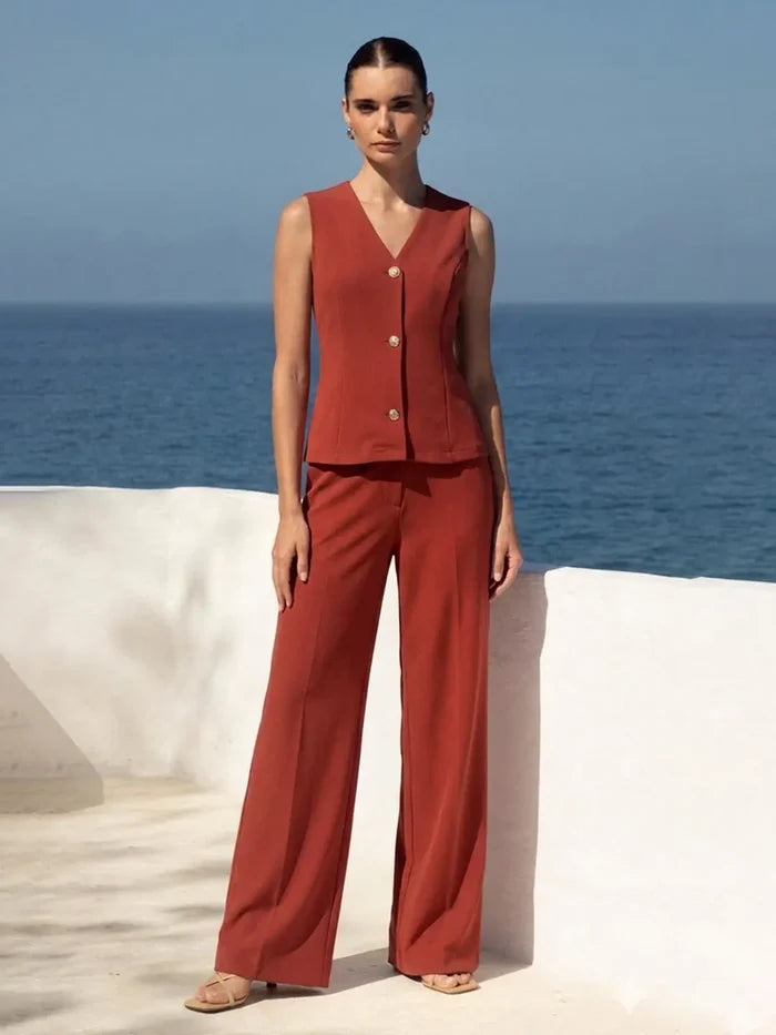 Woman in a red outfit standing against a blue sky and ocean