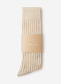 A pair of ribbed Percival Marl Socks in oat, folded and presented in a branded cardboard sleeve against a white background.
