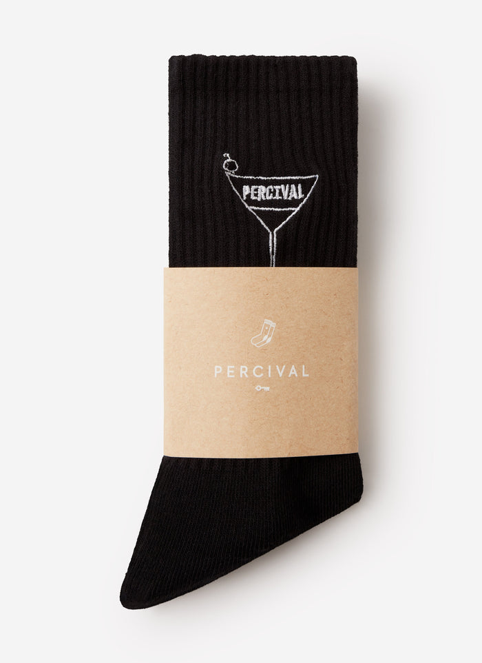 A pair of black Percival Martini Embroidered Socks, folded and wrapped in a branded sleeve against a white background.