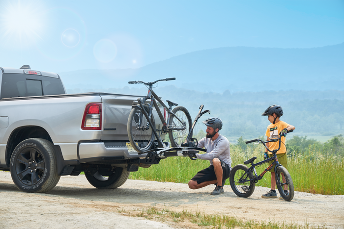 Rider loading a mountain bike onto the Saris MHS UNO 1-Bike Modular Hitch Rack