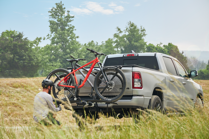 Cyclist securing bike on Saris MHS UNO Modular Hitch Rack at trailhead