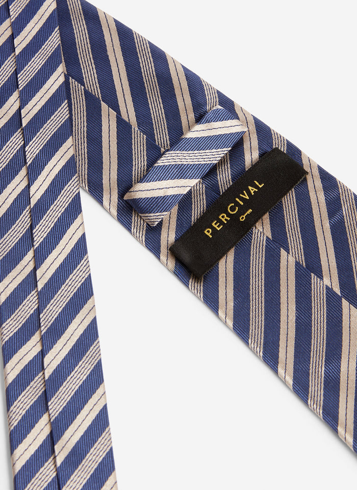 A close-up of the reverse of the Percival Micro Stripe Silk Tie in navy and beige, showing the brand label.