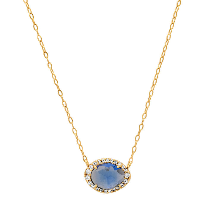 Gold oval gemstone pendant necklace with blue center stone and halo of clear crystals