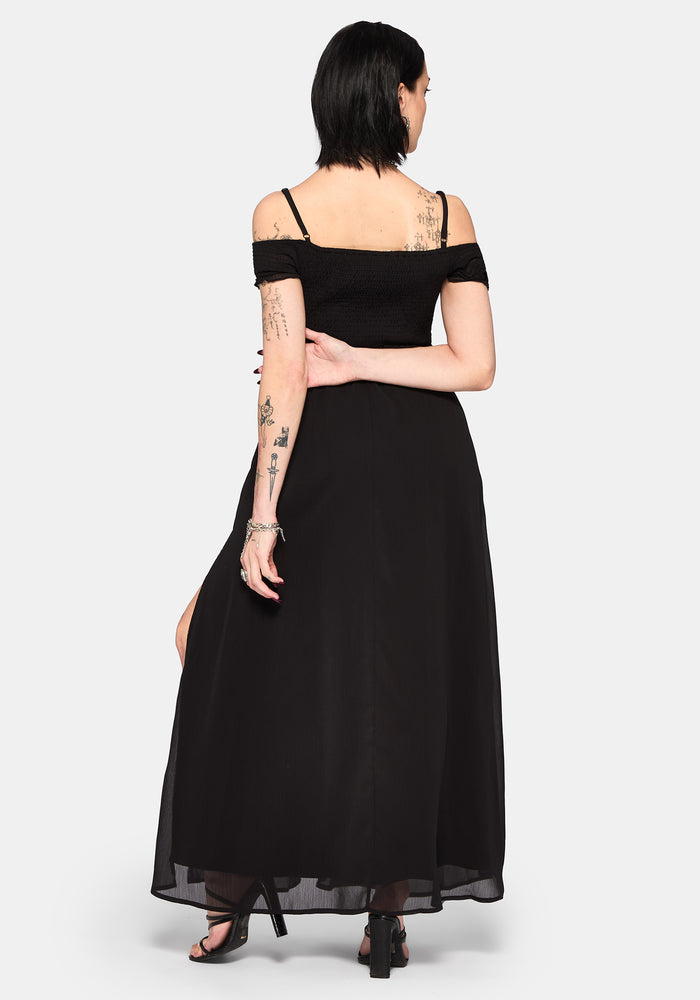 Woman wearing a black off-shoulder maxi dress on a white background