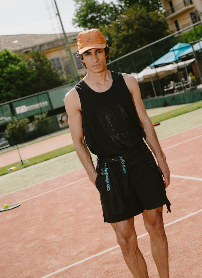 Black Percival PCVL Performance Vest featuring tonal artwork, worn by a model on an outdoor sports court.