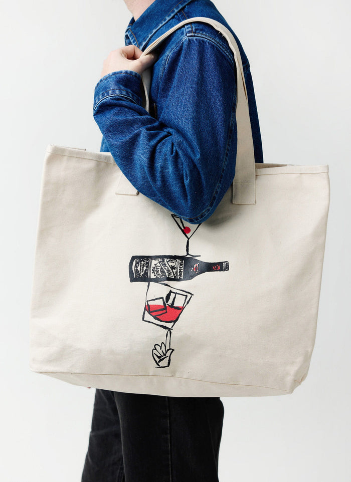 A model carrying the ecru Percival Perci and Rossi Martini tote bag, wearing a classic blue denim jacket.