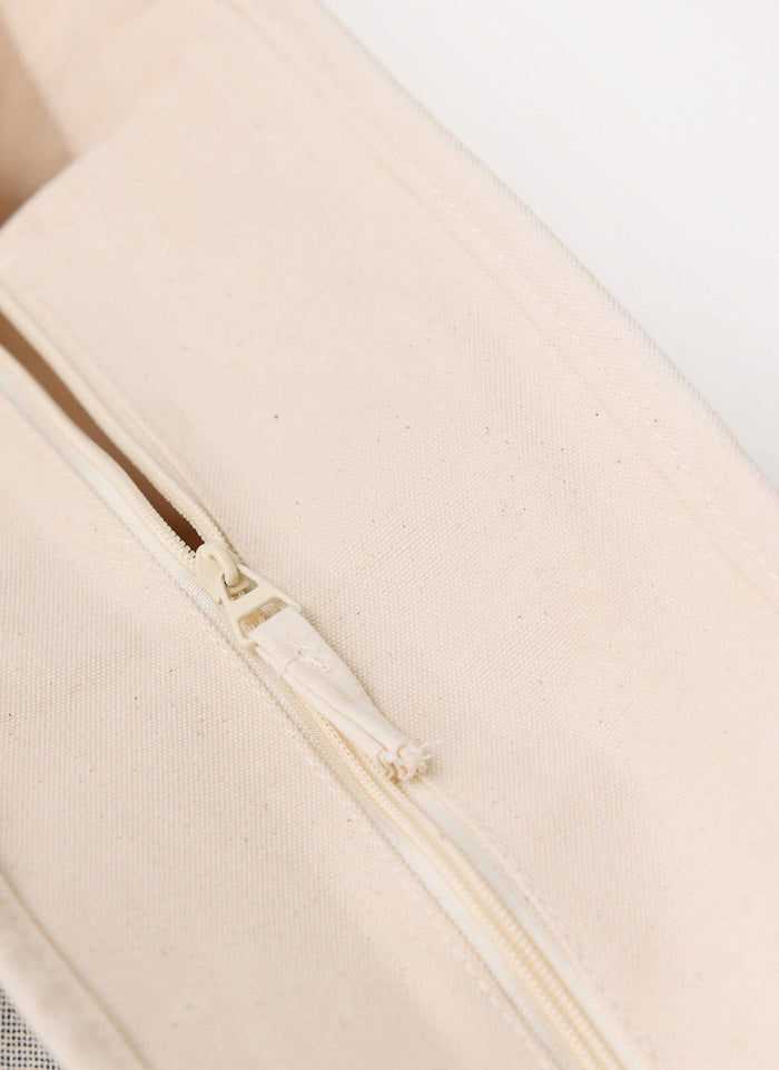 A close-up of the zip top detail on the Percival Perci and Rossi Martini Tote Bag, made from heavyweight ecru cotton.