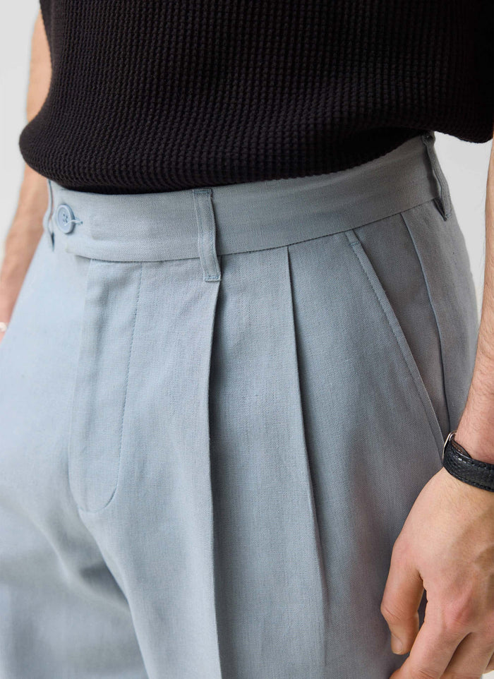 close up detail of the Percival light blue pleated linen tailored trousers