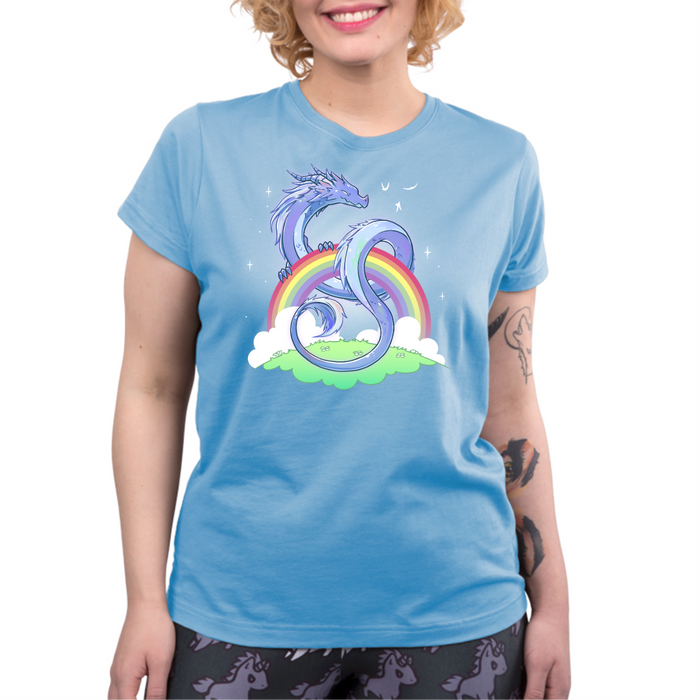 Premium Cotton T-shirt_TeeTurtle light blue Rainbow Protector Premium Cotton T-shirt featuring a smiling dragon protectively looped around a rainbow above a grassy area. There are sparkles around the dragon and rainbow.