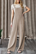 Woman wearing ribbed knit wide leg overalls with patch pockets layered over a short sleeve top, styled casually for everyday wear from The Pink Doxie Boutique.