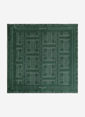 A flat lay of the Percival Sashiko Neckerchief in forest green silk, showing the full geometric stitch-inspired pattern.