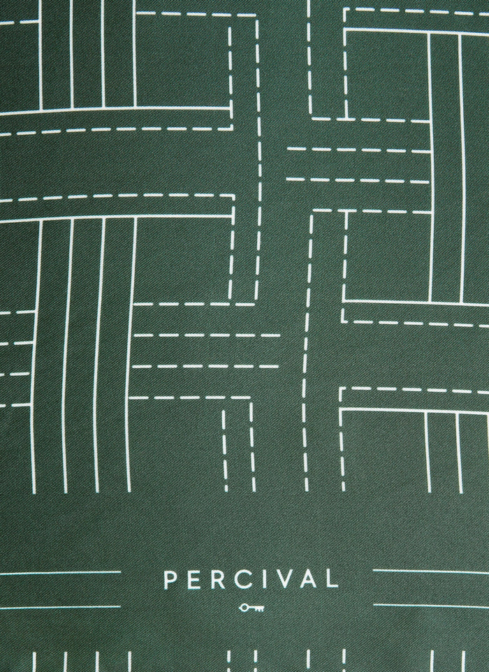 Close-up of the forest green silk Sashiko Neckerchief from Percival, showing the white geometric stitch pattern and logo.