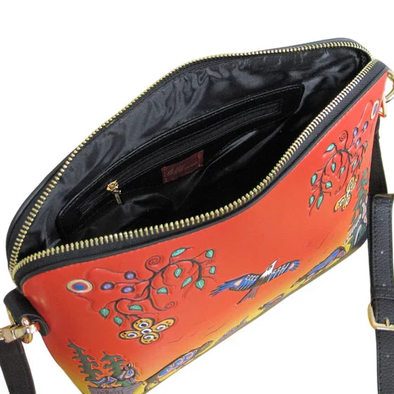 Orange handbag with floral and bird designs on a white background