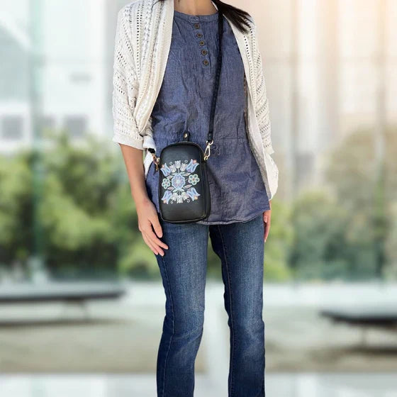 Person wearing a denim outfit with a floral-patterned bag outdoors