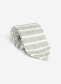 A studio shot of the Percival Stripe Linen Tie in Forest Marl, rolled up to show its green and white striped linen texture.