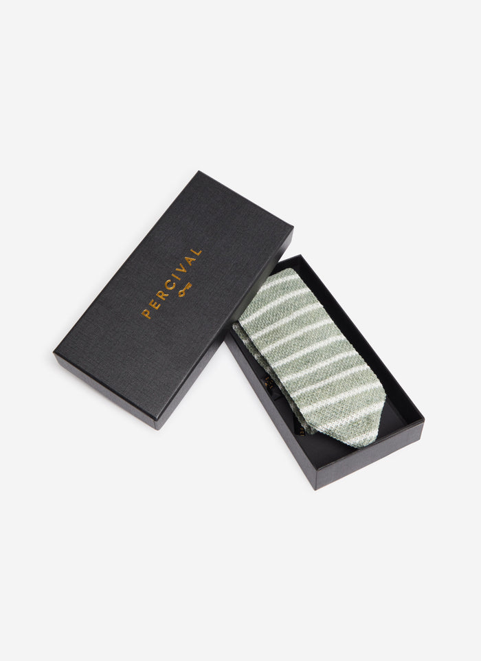 The Percival Stripe Linen Tie in Forest Marl, shown folded neatly inside its black branded presentation box.