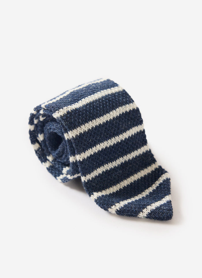 A rolled up Percival navy marl and white striped linen tie, shown on a white background.